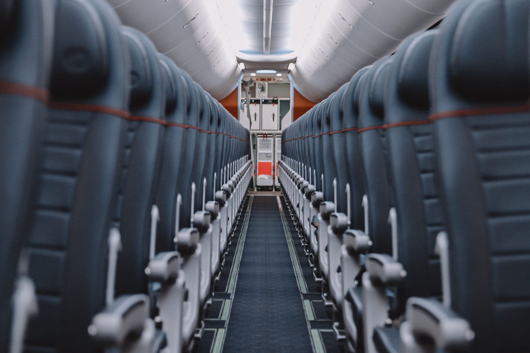 View down the aisle of an empty airplane cabin showing seats and overhead compartments