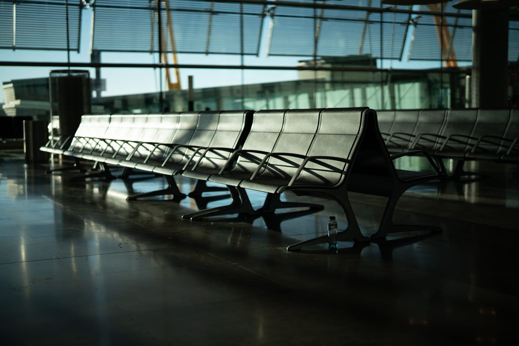 Deserted airport seating area with sunlight through large windows