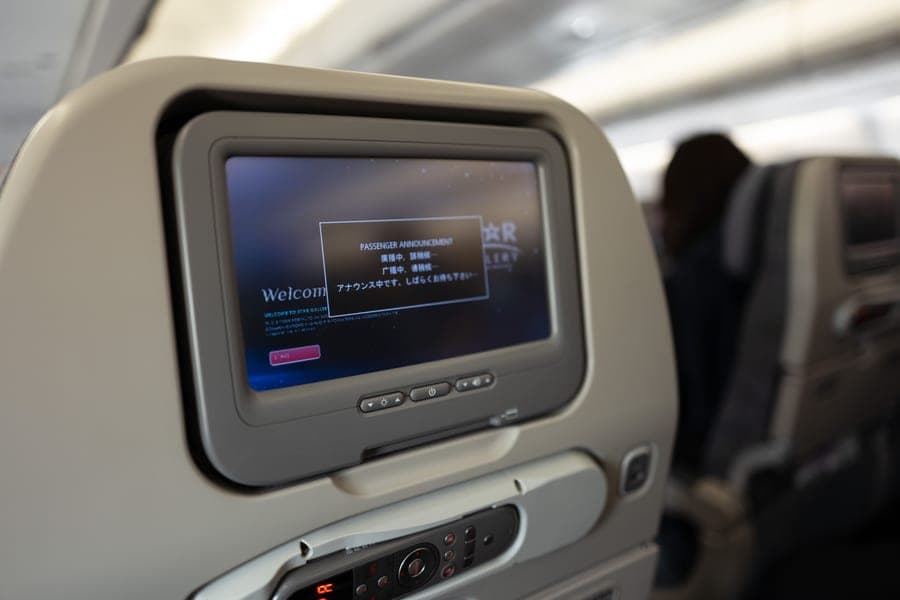 Airplane seatback screen showing an onboard passenger announcement